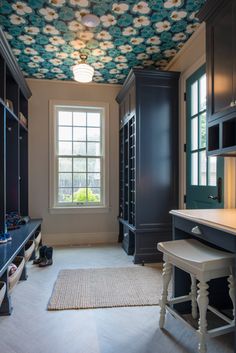 the room is decorated in blue and white with flowers on the ceiling, along with black cabinets