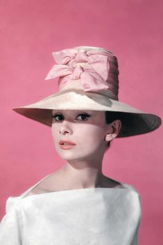 a woman in a white dress and pink hat with the caption, my obsession with eyeliner started this way