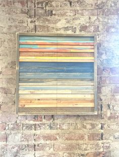 a painting hanging on the side of a brick wall