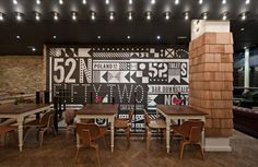 a restaurant with wooden tables and chairs in front of a large mural on the wall