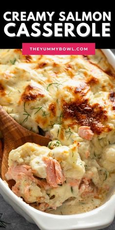 creamy salmon casserole in a white dish with a wooden spoon on the side