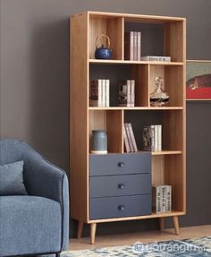 a living room with a blue chair and book shelf