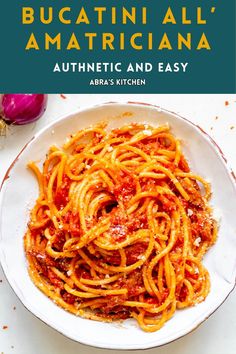 a white bowl filled with spaghetti and sauce on top of a table next to garlic