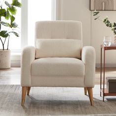 a white chair sitting on top of a rug next to a window