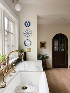 a kitchen with marble counter tops and gold faucets on the wall above it