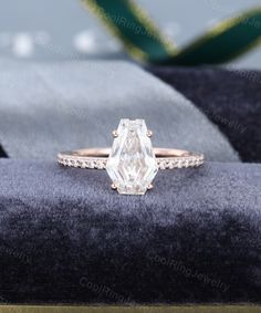 an engagement ring with a large diamond in the center on top of a velvet cushion