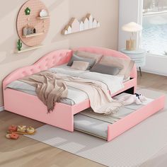 a pink bed sitting on top of a wooden floor