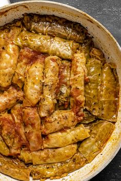 a pan filled with chicken and artichokes covered in marinara sauce on top of a table