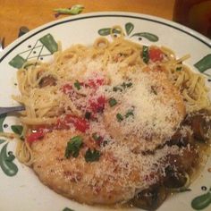 a plate of pasta with meat and cheese on the top is sitting on a table