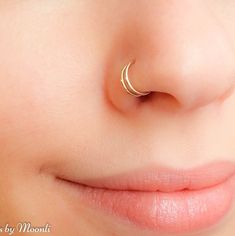 a close up of a child's nose with a gold nose ring