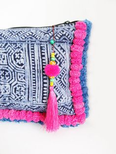 a crocheted pouch with tassels and beads