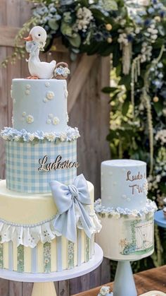 two tiered cakes with blue and white designs on them, one has a duck sitting on top