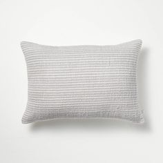 a white pillow sitting on top of a white wall