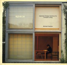 a woman sitting at a table in front of a window with the words space on it