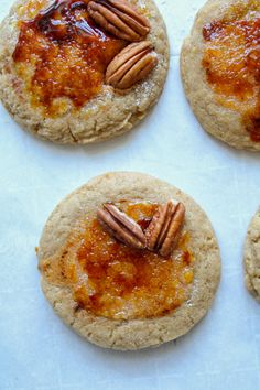 four cookies with jam and pecans on top