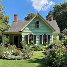 a green house surrounded by flowers and trees