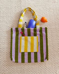 a striped bag with toys in it sitting on the floor