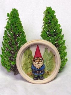 a small gnome figurine sitting in front of some trees