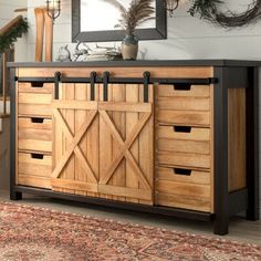 a wooden dresser with drawers and doors on top of it in front of a mirror