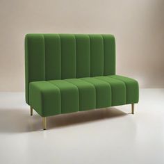 a green couch sitting on top of a white floor next to a wall in an empty room