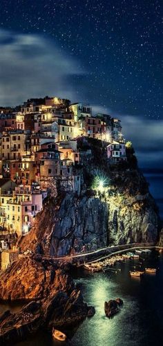 the night sky is lit up over an island with boats on it