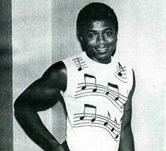 a black and white photo of a young man with musical notes on his tank top