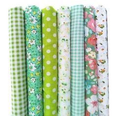 many different types of fabric are lined up in the same row, each with flowers and gingham