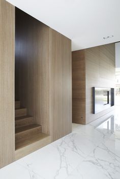 the interior of a house with marble floors and wooden walls, along with an open staircase