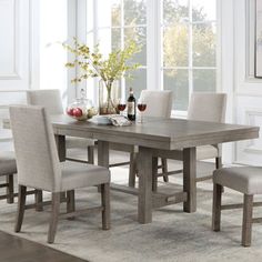 a dining room table and chairs in front of a window