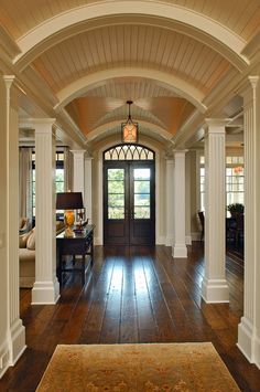 an entry way with wooden floors and columns