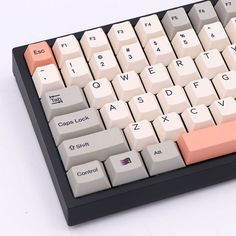 a white and black computer keyboard with orange keys