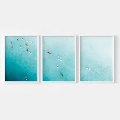 three framed photographs hanging on a wall above the ocean with surfers in the water