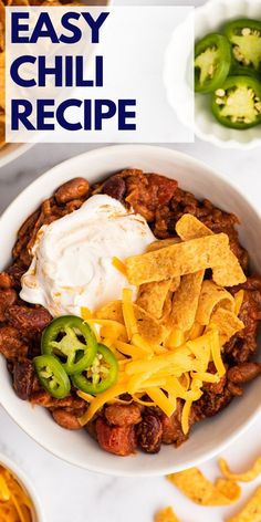 a bowl filled with chili, cheese and tortilla chips on top of a table