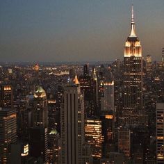 the city skyline is lit up at night with skyscrapers in the foreground and lights on all sides