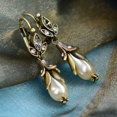 "Pearl lily flowers convey an elegant vintage look, suitable for everyday wear. Lever back is mounted with Swarovski crystal accents. Romantic and feminine. Beautiful choice for weddings...give a pair to each of your bridesmaids, gift it to the Mother of the Bride or Groom or wear as your own bridal jewelry. Burnished bronze metal finish. Size: 1.75\" long by 0.5\" wide Made in our Los Angeles, CA studio. Contact us for bulk pricing and wholesale information." Flower Earrings Wedding, French Earrings, Lily Earrings, French Jewelry, Jewelry Flower, Jewelry Pearl, Jewelry Bridesmaid, Earrings Flower, Jewelry Crystal