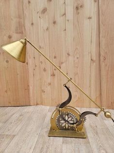 a desk lamp sitting on top of a wooden floor next to a wood paneled wall