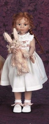 an old doll holding two stuffed animals in it's arms and wearing a white dress