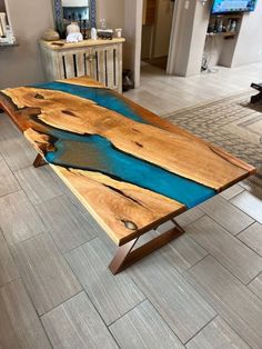 a wooden table sitting on top of a tile floor next to a tv monitor screen