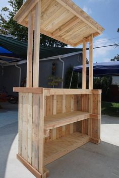 a wooden structure with shelves built into the top and bottom, in front of a building