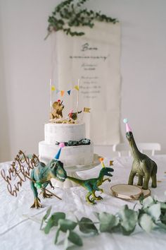 dinosaur figurines and cake on a table