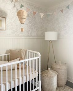 a white crib in a room with two baskets on the floor next to it