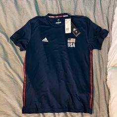 Nwt Adidas Olympic Games Usa Volleyball Navy Blue Short Sleeve Shirt. Unisex. Size S. Fabric Is Stretchy Workout Material. Adidas T-shirt For Sports Season Workouts, Adidas Graphic Print Workout T-shirt, Adidas Sporty Tops For Sports Events, Blue Adidas Tops For Sports Season, Blue Adidas Sportswear T-shirt, Adidas Crew Neck Go-dry Tops, Volleyball Fits, Volleyball Team Shirts, Usa Volleyball