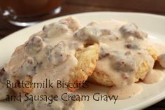 two biscuits covered in gravy on a white plate