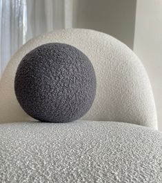 a gray ball sitting on top of a white chair