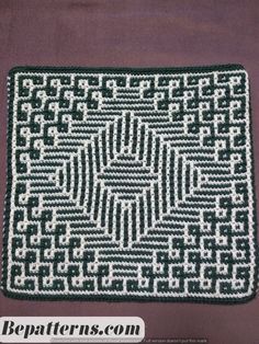 a crocheted square with an intricate design on the center and sides, in green and white