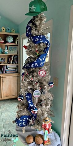 a decorated christmas tree in the corner of a room with bookshelves and other items