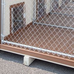 an image of a dog door behind a chain link fence