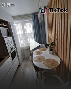 a kitchen with a table and chairs in front of a window next to a stove top oven