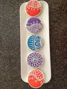 four decorated cookies sitting on top of a white plate