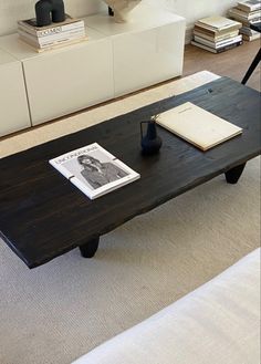 a coffee table with a book on it in a living room